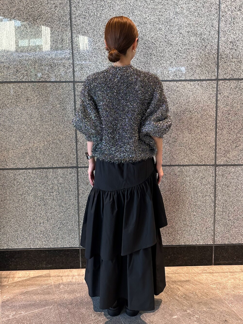 ブラック系のニット/セーター、ブラック系のスカートを着用したレディースの秋コーディネートの3枚目の写真