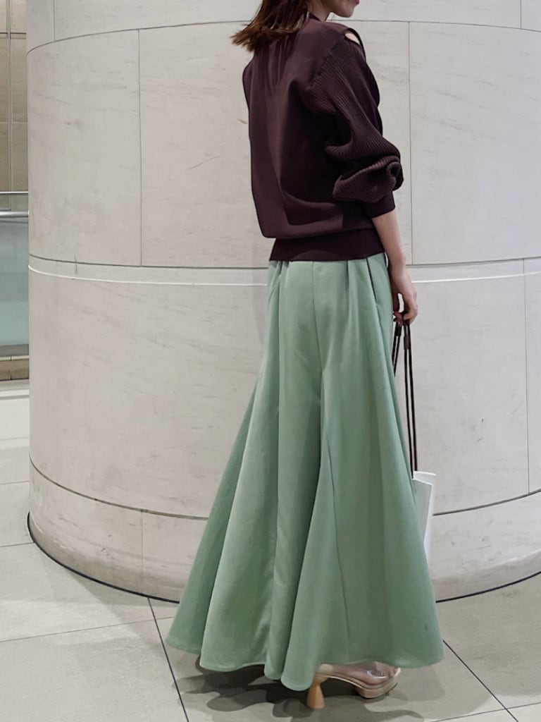 その他のパンプス、グリーン系のスカート、ホワイト系のハンドバッグを着用したレディースの冬コーディネートの2枚目の写真