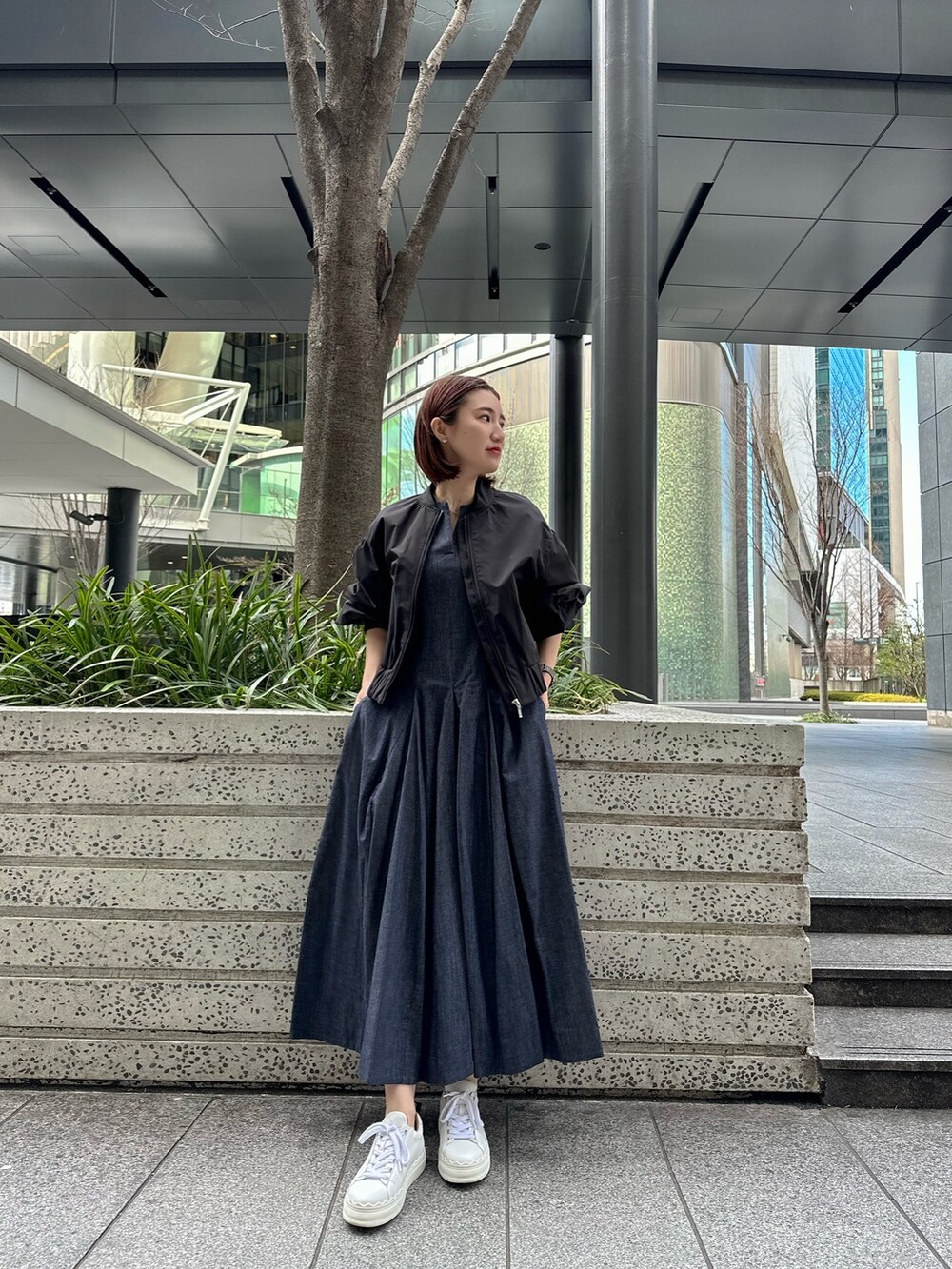 ホワイト系のスニーカー、ブルー系のワンピース、ブラック系のブルゾンを着用したレディースの春コーディネートの4枚目の写真