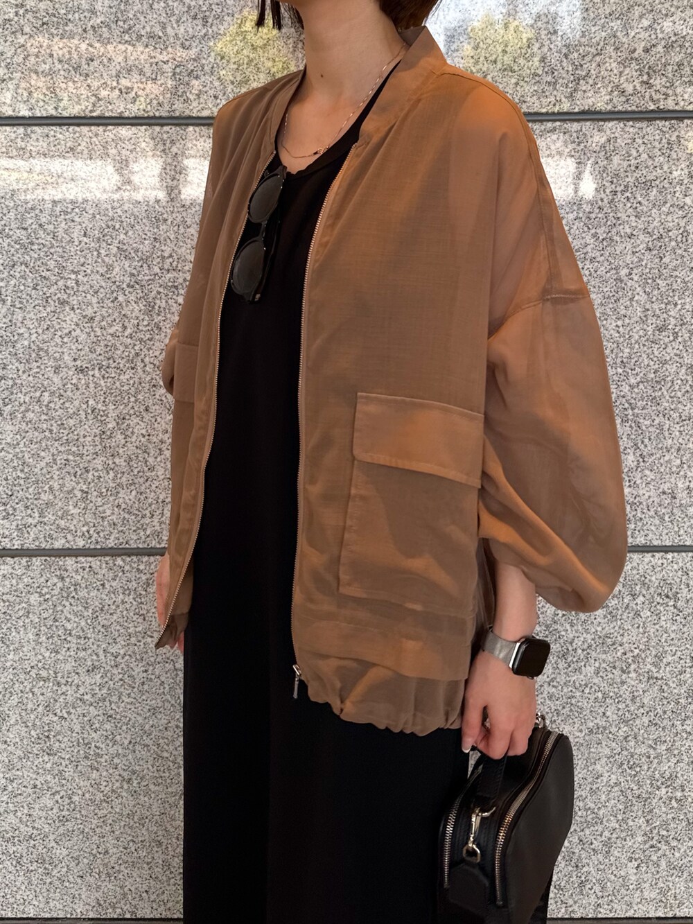 ベージュ系のブルゾン、ブラック系のワンピース、ブラック系のサングラスを着用したレディースの夏コーディネートの4枚目の写真