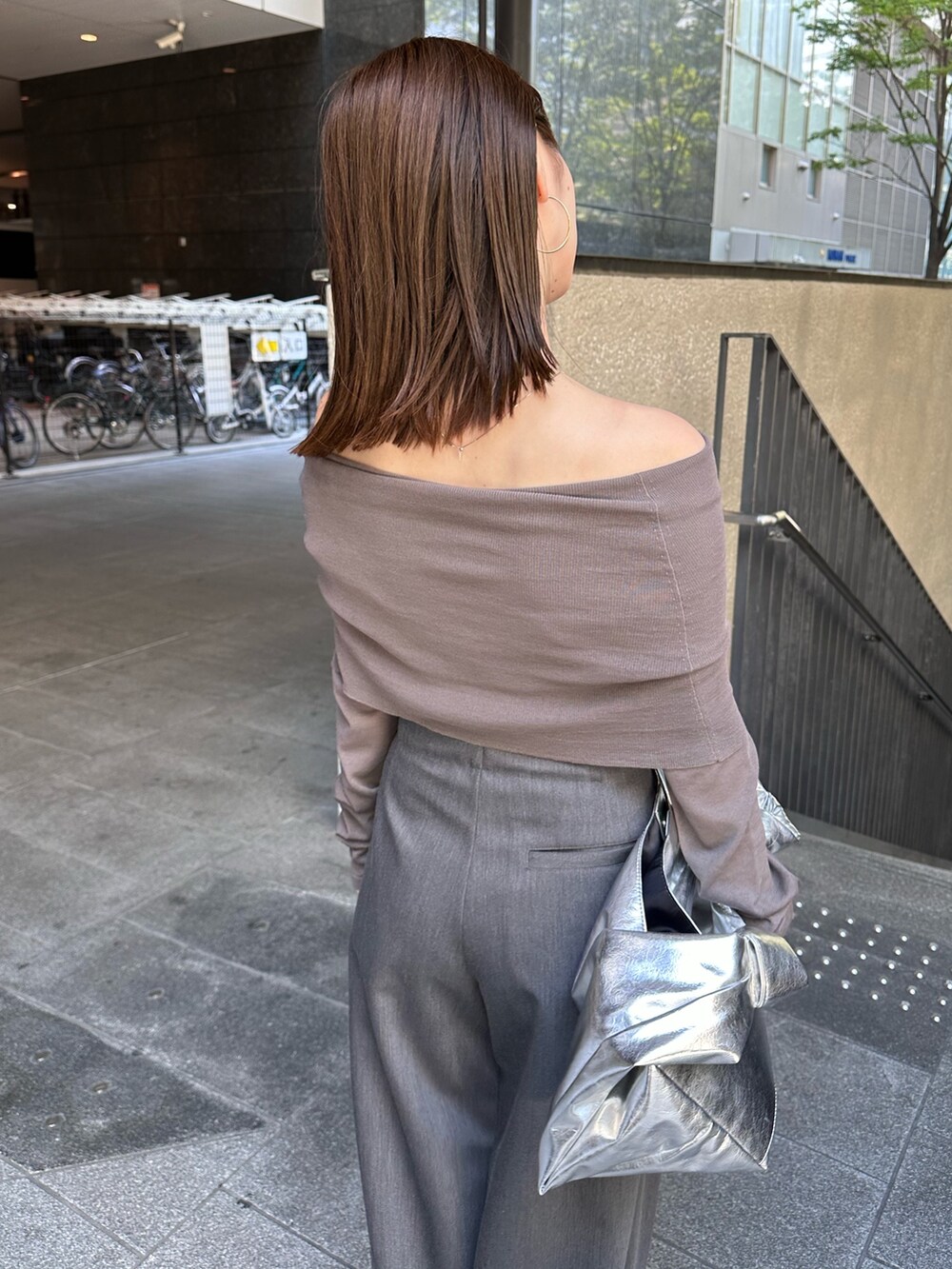 グレー系のニット/セーター、グレー系のその他パンツ、シルバー系のトートバッグを着用したレディースの夏コーディネートの6枚目の写真