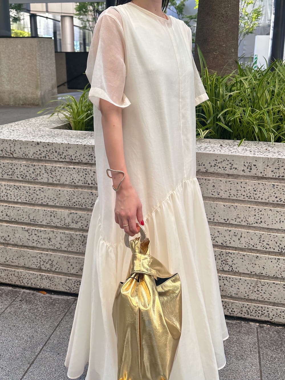 ブラック系のキャミソール、ゴールド系のハンドバッグ、ブラック系のサンダルを着用したレディースの夏コーディネートの5枚目の写真