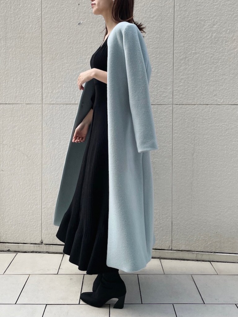 ブルー系のノーカラーコート、ブラック系のワンピースを着用したレディースの冬コーディネートの5枚目の写真