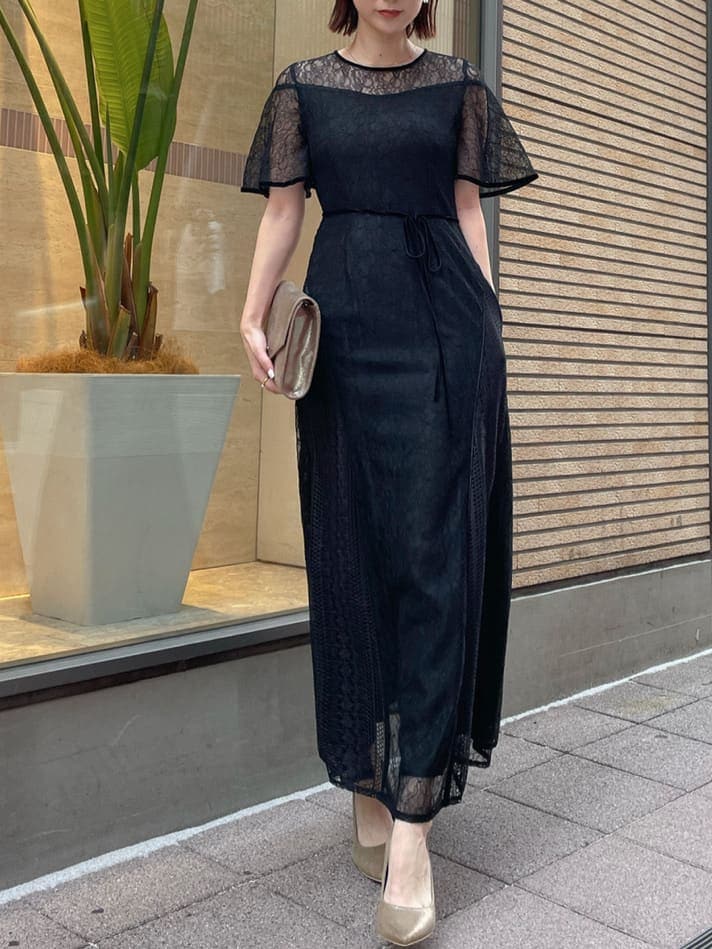 ゴールド系のパンプス、ゴールド系のクラッチバッグ、ブラック系のドレスを着用したレディースの夏コーディネートの4枚目の写真