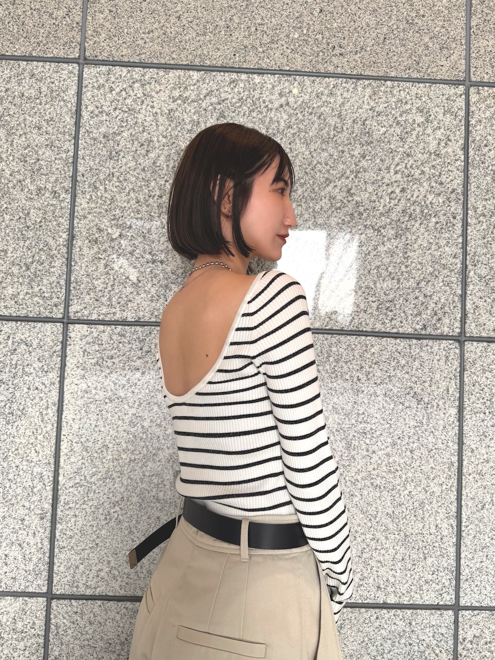 ホワイト系のその他パンツ、ブラック系のハンドバッグ、その他のニット/セーターを着用したレディースの春コーディネートの4枚目の写真