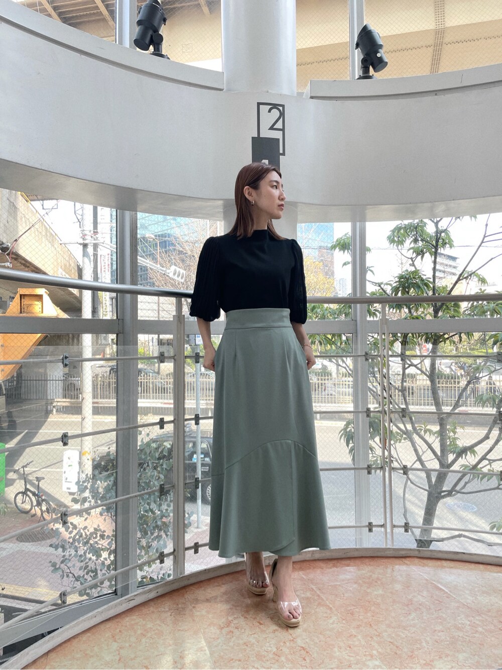 グリーン系のスカート、その他のパンプス、ベージュ系のその他アウターを着用したレディースの春コーディネートの4枚目の写真