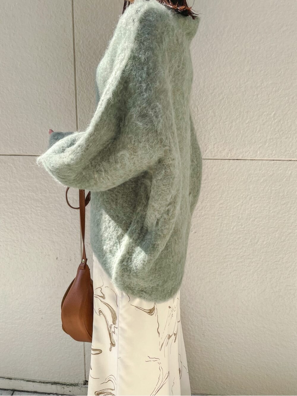 ベージュ系のブーツ、ブラウン系のショルダーバッグ、ホワイト系のスカートを着用したレディースの秋コーディネートの4枚目の写真