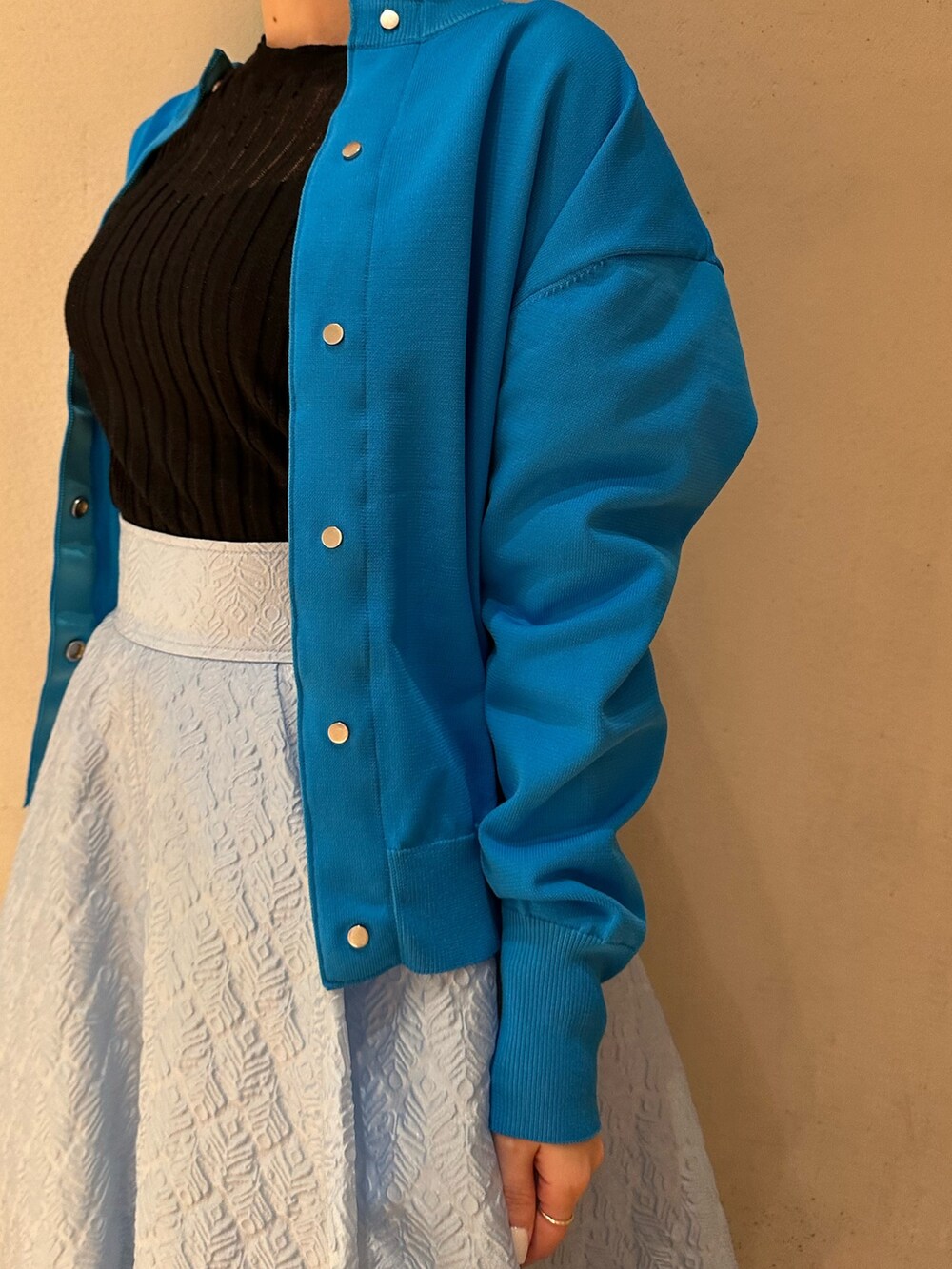 ブルー系のスカート、ブラック系のスニーカー、ブルー系のカーディガン/ボレロを着用したレディースの春コーディネートの3枚目の写真