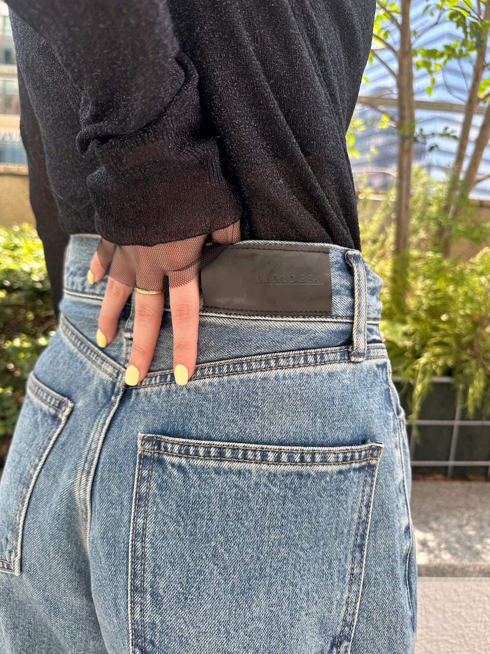 ブルー系のデニムパンツ、ブラック系のパンプス、ブラック系のニット/セーターを着用したレディースの夏コーディネートの9枚目の写真