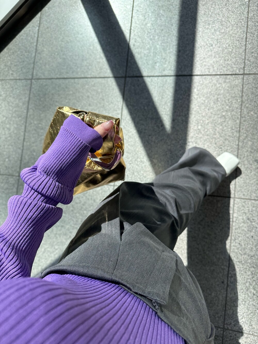 パープル系のニット/セーター、グレー系のその他パンツ、ゴールド系のハンドバッグを着用したレディースの春コーディネートの7枚目の写真