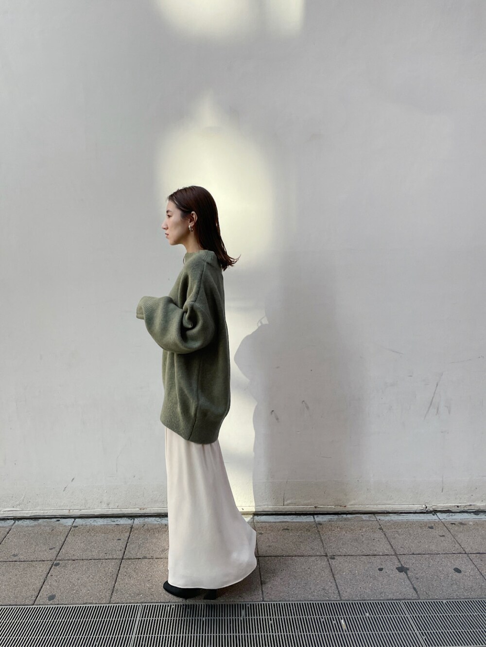 ホワイト系のスカート、ベージュ系のニット/セーターを着用したレディースの冬コーディネートの2枚目の写真