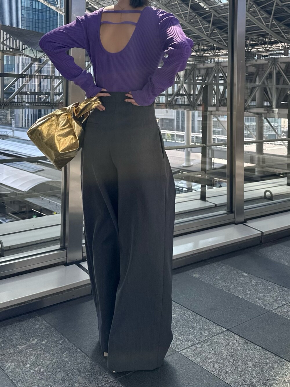 パープル系のニット/セーター、グレー系のその他パンツ、ゴールド系のハンドバッグを着用したレディースの春コーディネートの6枚目の写真