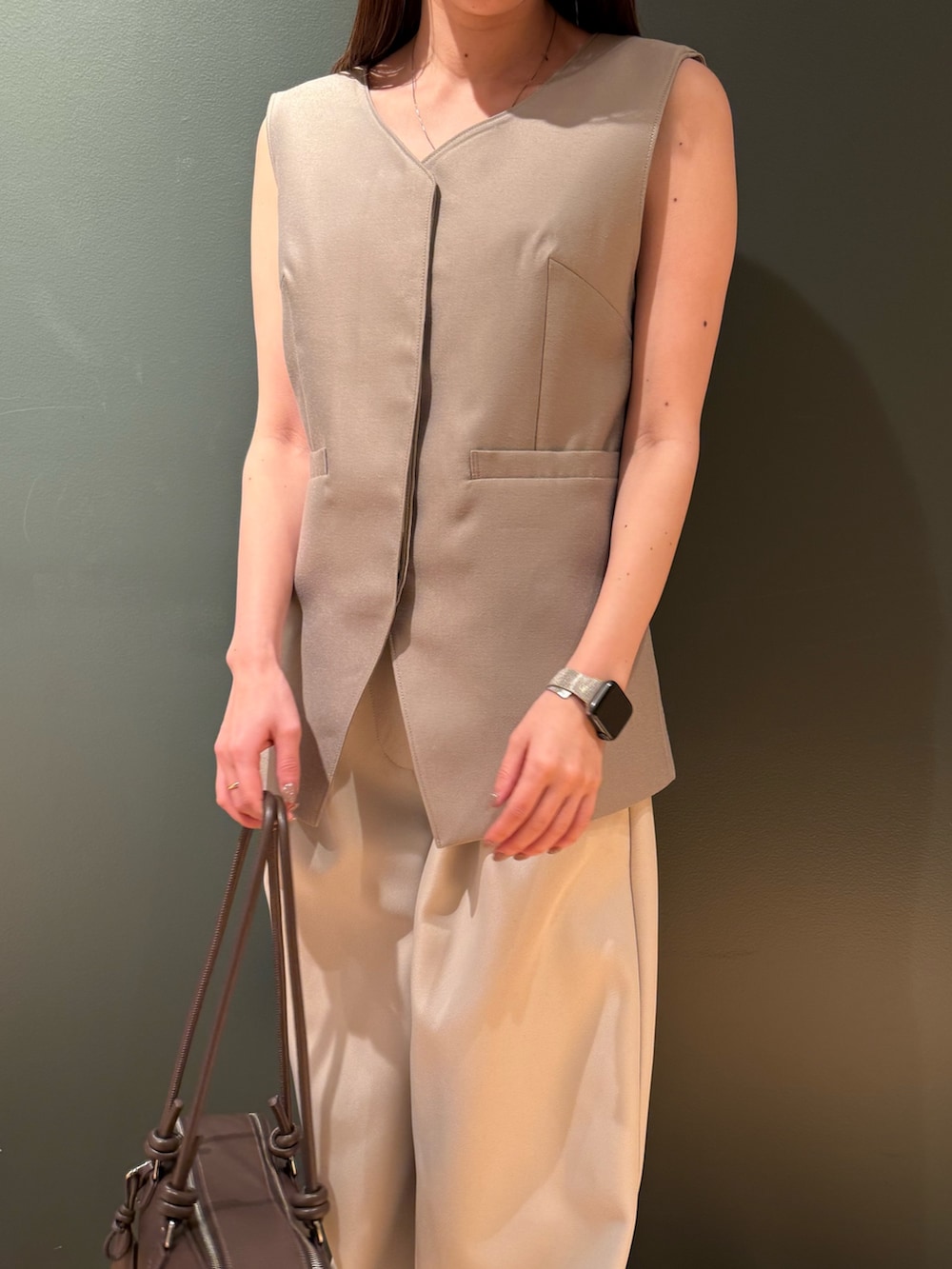 ベージュ系のベスト、ホワイト系のその他パンツ、ブラック系のボストンバッグを着用したレディースの冬コーディネートの6枚目の写真