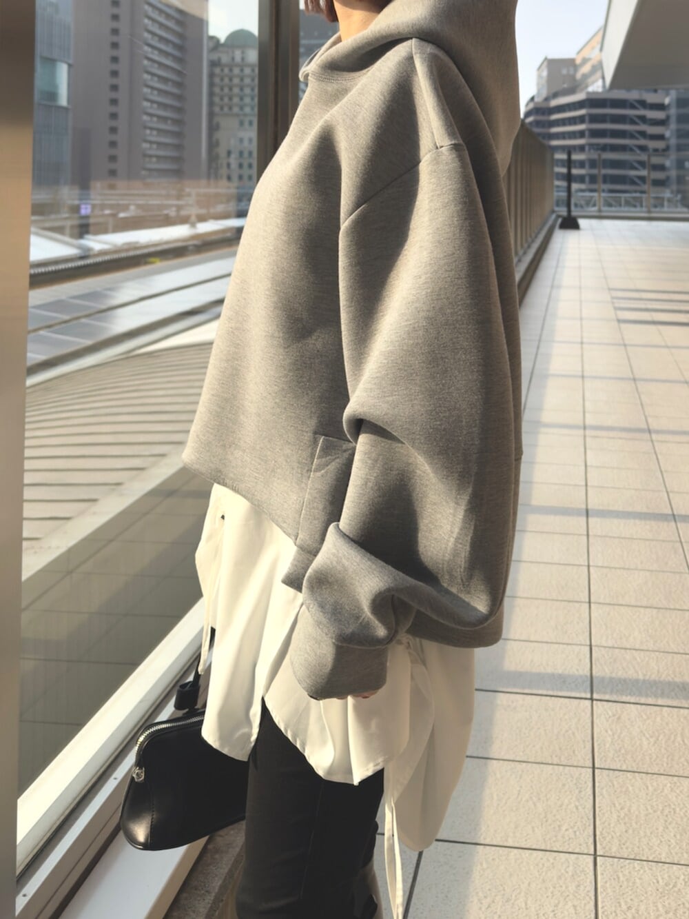 グレー系のパーカー、ブラック系のボストンバッグを着用したレディースの冬コーディネートの7枚目の写真