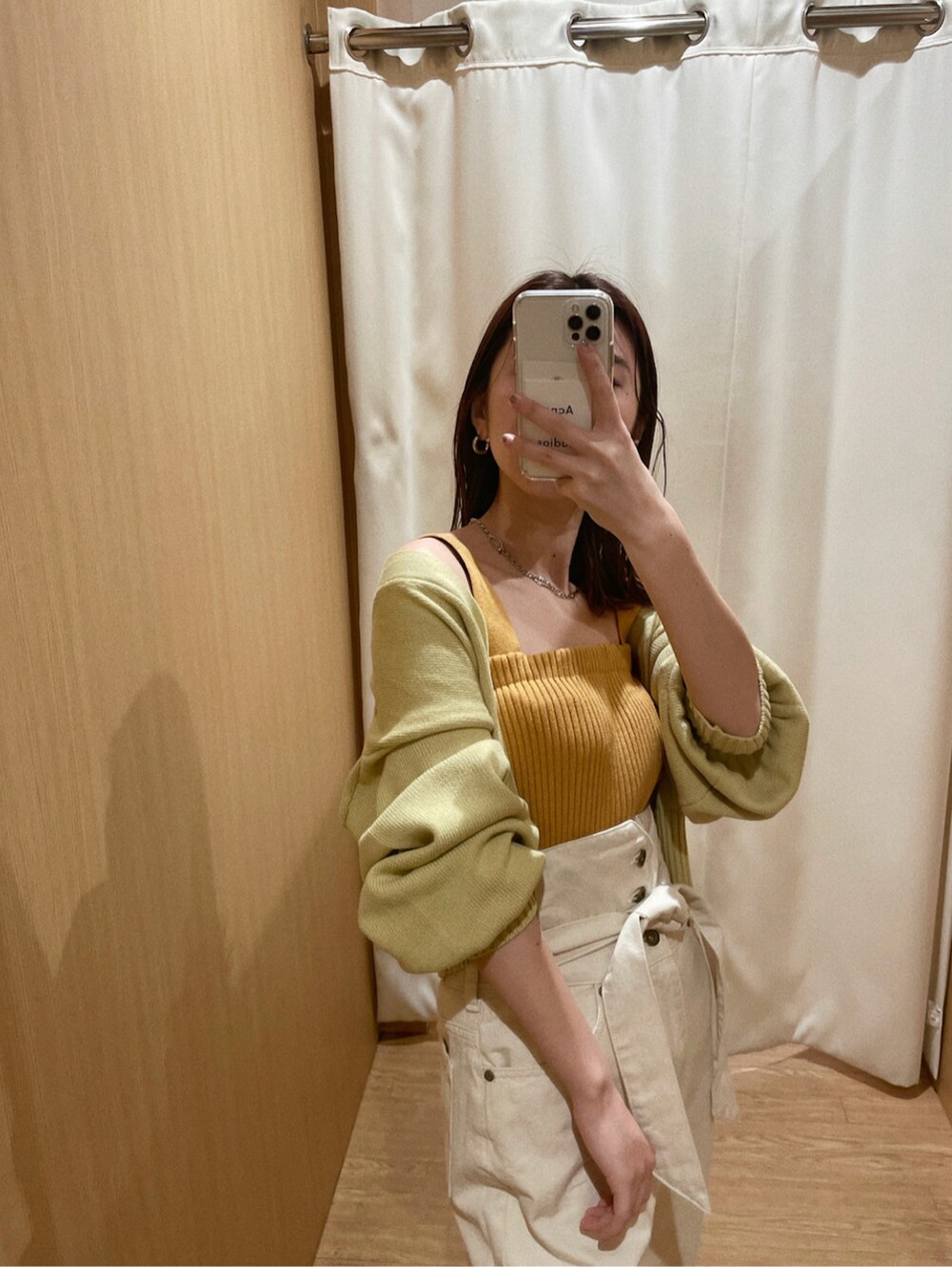 ホワイト系のデニムパンツ、ブラウン系のパンプス、パープル系のハンドバッグを着用したレディースの冬コーディネートの2枚目の写真