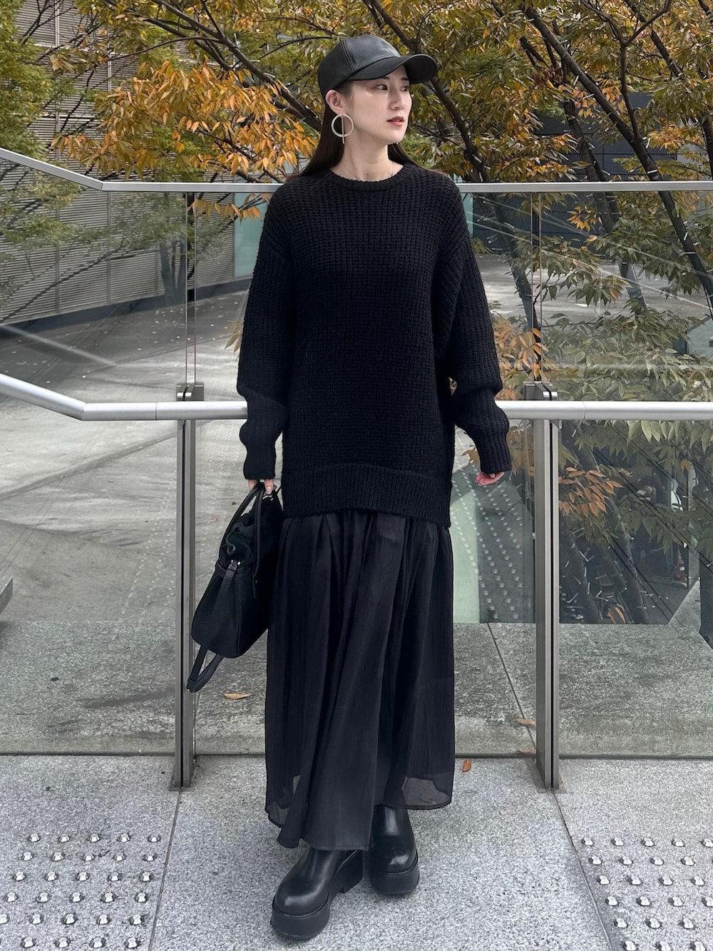 ブラック系のワンピース、ブラック系のショルダーバッグ、ブラック系のキャップを着用したレディースの秋コーディネートの3枚目の写真