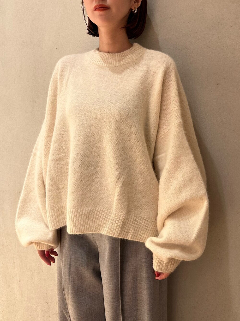 ホワイト系のニット/セーター、グレー系のその他パンツ、ブラック系のブーティを着用したレディースの秋コーディネートの3枚目の写真