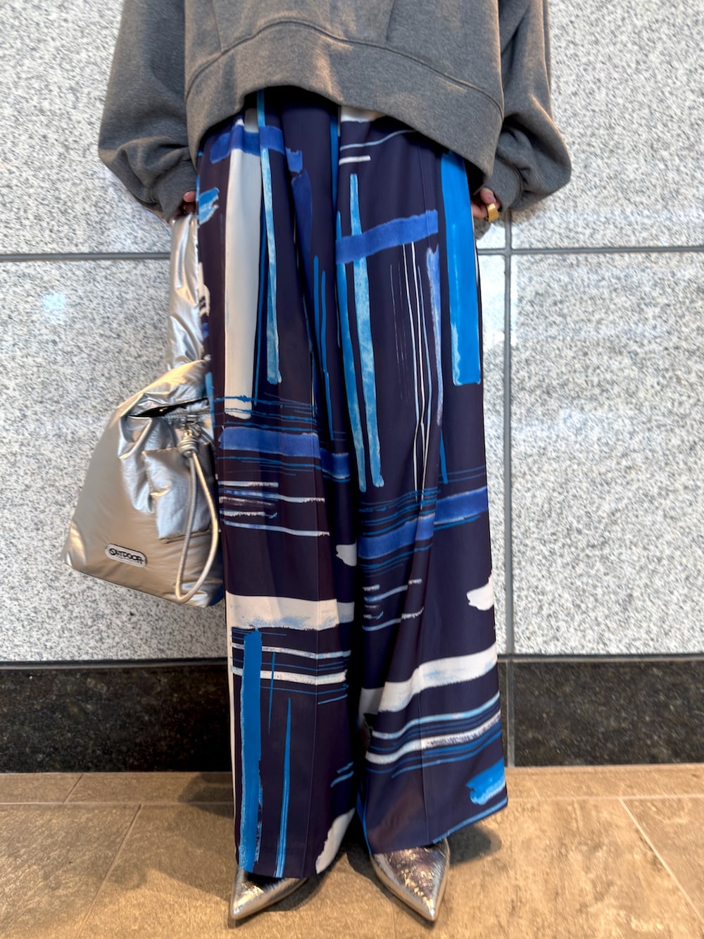 グレー系のTシャツ/カットソー、シルバー系のハンドバッグ、ブルー系のその他パンツを着用したレディースの冬コーディネートの5枚目の写真