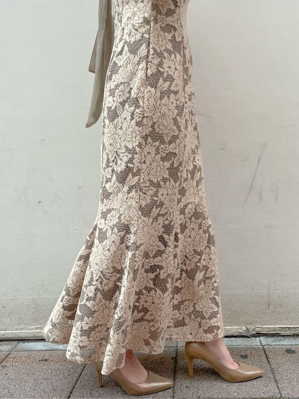 ベージュ系のドレス、ゴールド系のパンプス、ベージュ系のクラッチバッグを着用したレディースの夏コーディネートの8枚目の写真