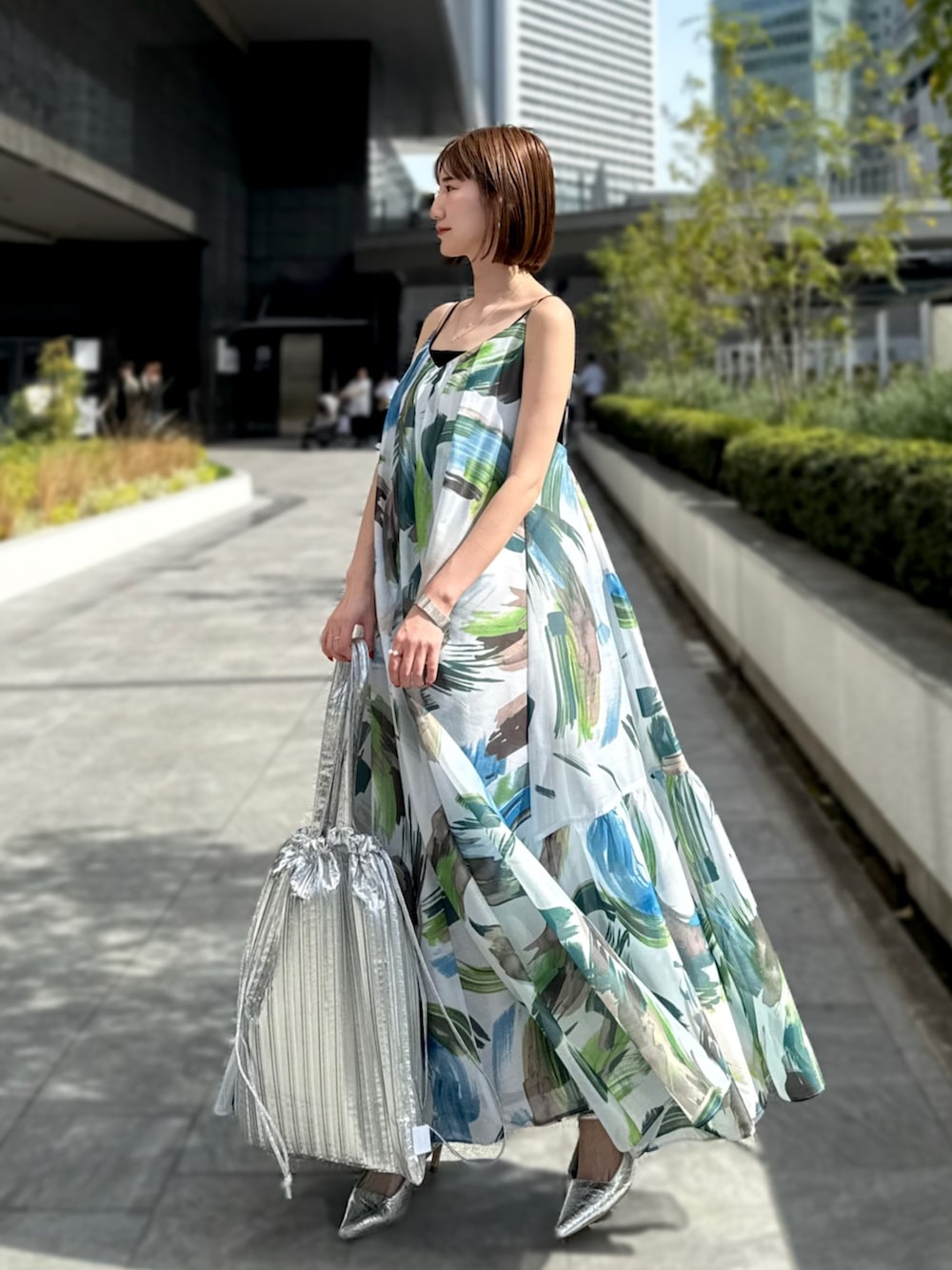グリーン系のワンピース、シルバー系のトートバッグ、シルバー系のサンダルを着用したレディースの春コーディネートの3枚目の写真