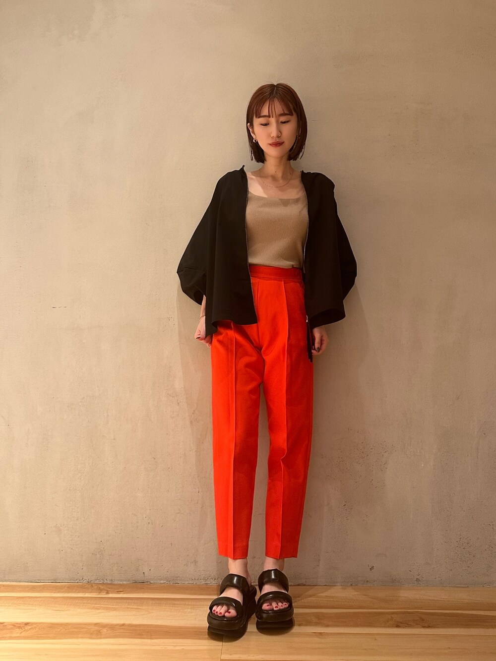 ブラック系のブルゾン、ブラック系のサンダル、ベージュ系のタンクトップを着用したレディースの春コーディネートの3枚目の写真