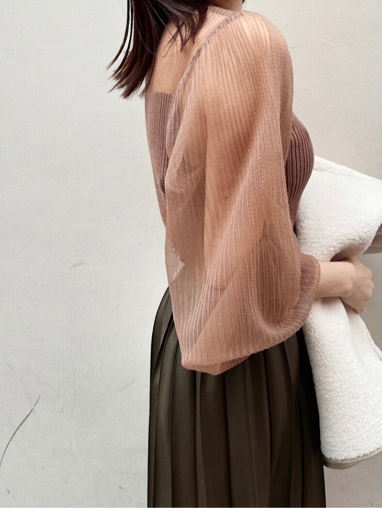 ブラウン系のスカート、ホワイト系のムートンコート、ベージュ系のニット/セーターを着用したレディースの冬コーディネートの2枚目の写真