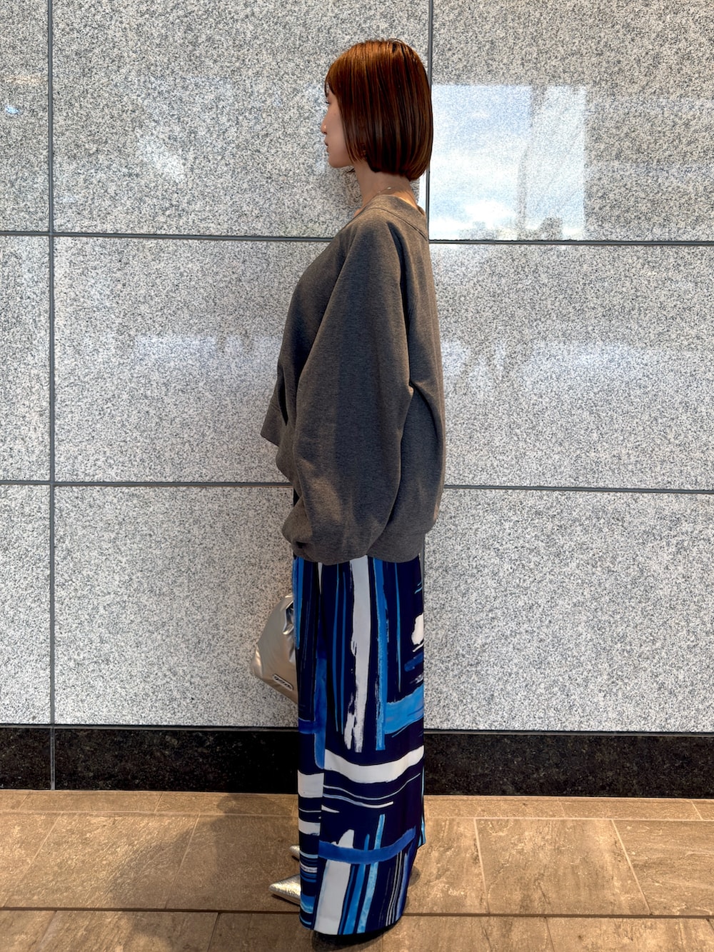 グレー系のTシャツ/カットソー、シルバー系のハンドバッグ、ブルー系のその他パンツを着用したレディースの冬コーディネートの2枚目の写真