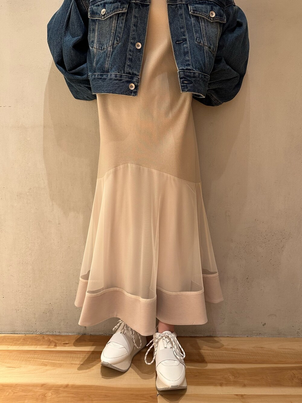 ブルー系のデニムジャケット、ベージュ系のワンピース、ホワイト系のスニーカーを着用したレディースの春コーディネートの7枚目の写真