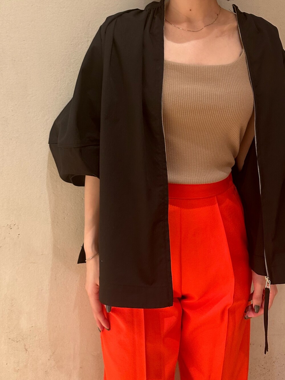 ブラック系のブルゾン、ブラック系のサンダル、ベージュ系のタンクトップを着用したレディースの春コーディネートの6枚目の写真