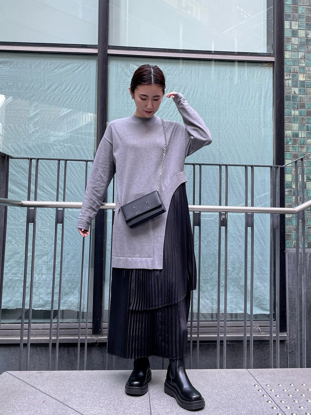 グレー系のワンピース、ブラック系のダウンジャケット/コート、ブラック系の財布を着用したレディースの冬コーディネートの5枚目の写真