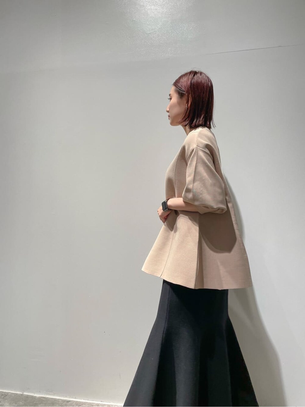 ベージュ系のニット/セーター、ブラウン系のノーカラーコート、ブラック系のブーツを着用したレディースの秋コーディネートの3枚目の写真