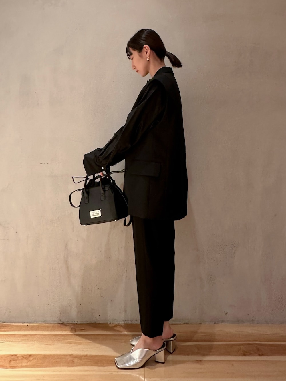 ブラック系のショルダーバッグ、ブラック系のテーラードジャケット、ブラック系のその他パンツを着用したレディースの春コーディネートの2枚目の写真