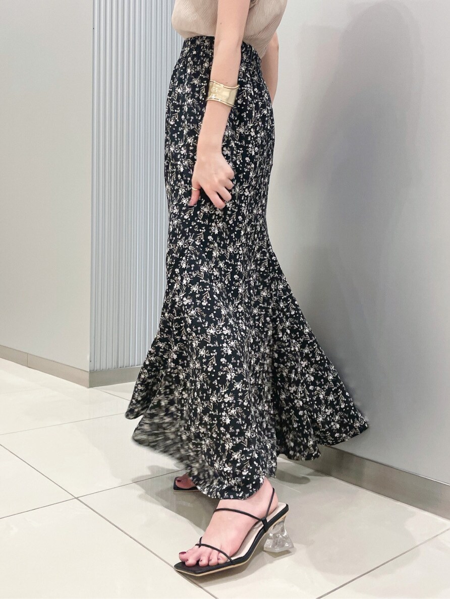 ブラック系のサンダル、ベージュ系のニット/セーター、ブラック系のスカートを着用したレディースの春コーディネートの2枚目の写真