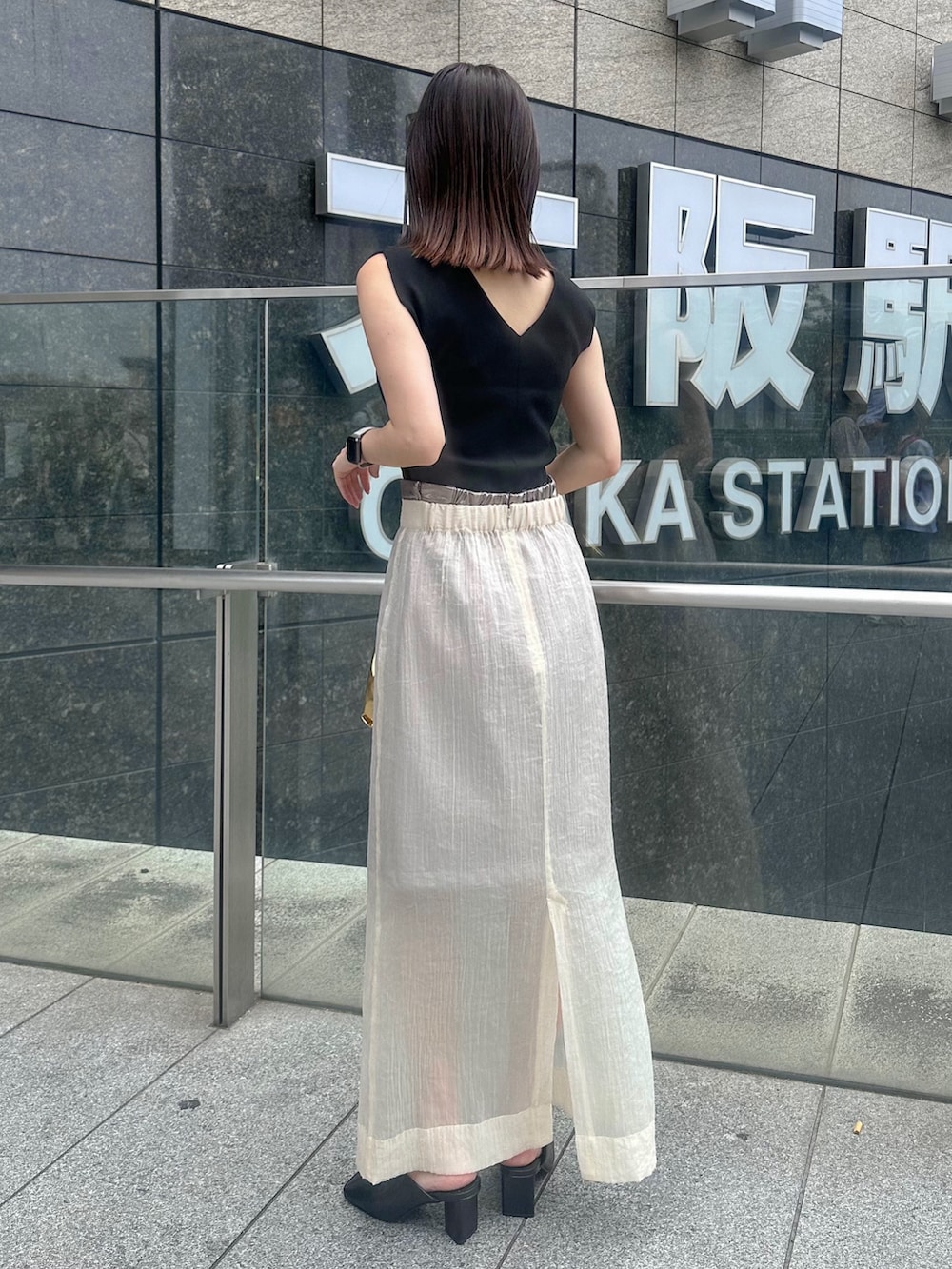 ブラック系のパンプス、ベージュ系のスカート、ブラック系のタンクトップを着用したレディースの夏コーディネートの4枚目の写真