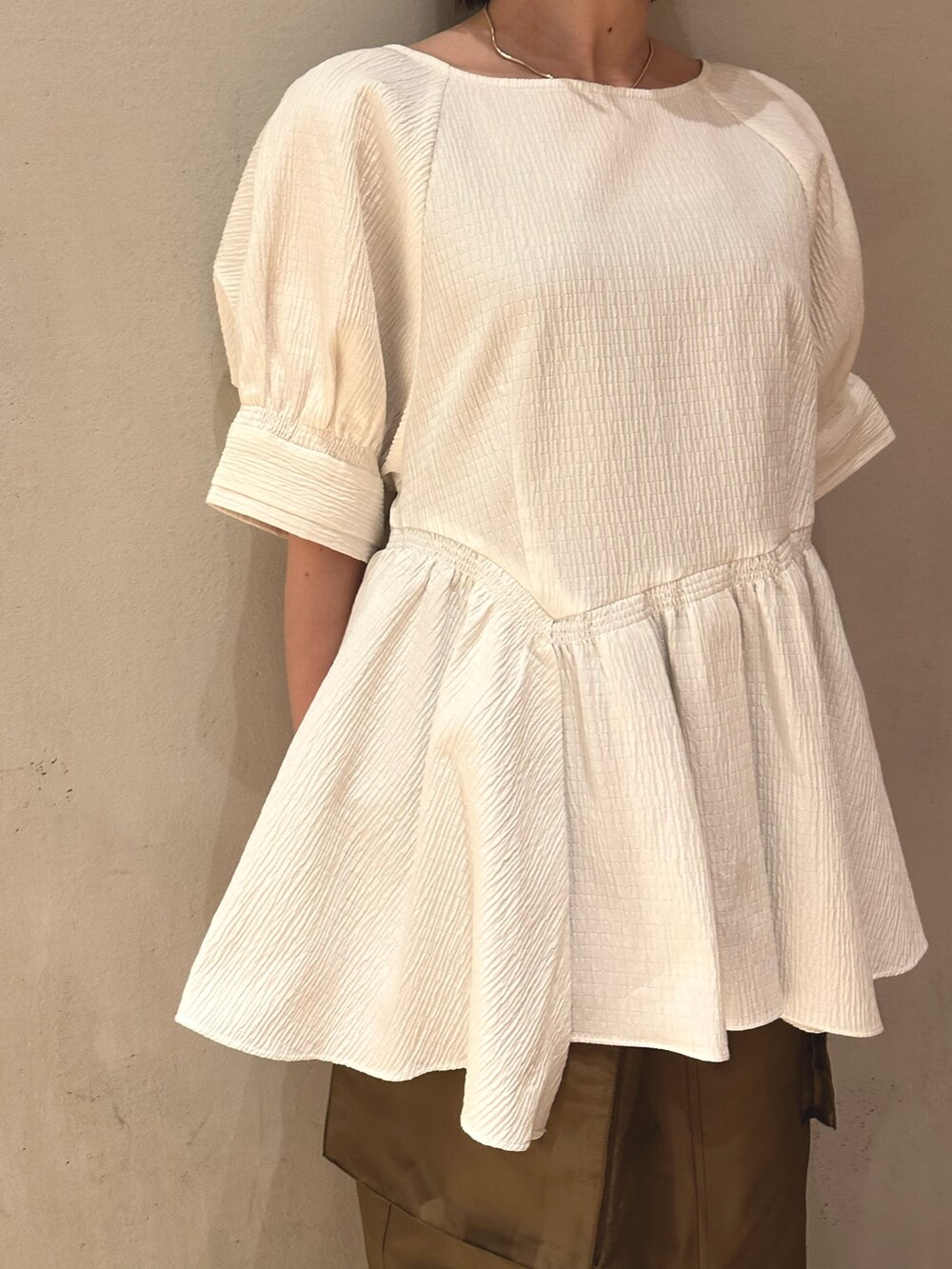 ブラウン系のスカート、ブラック系のスニーカー、ホワイト系のシャツ/ブラウスを着用したレディースの春コーディネートの4枚目の写真