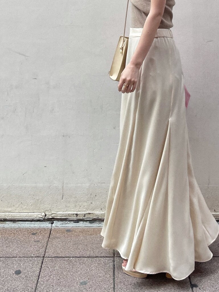 ホワイト系のスカート、その他のパンプス、ベージュ系のハンドバッグを着用したレディースの春コーディネートの7枚目の写真