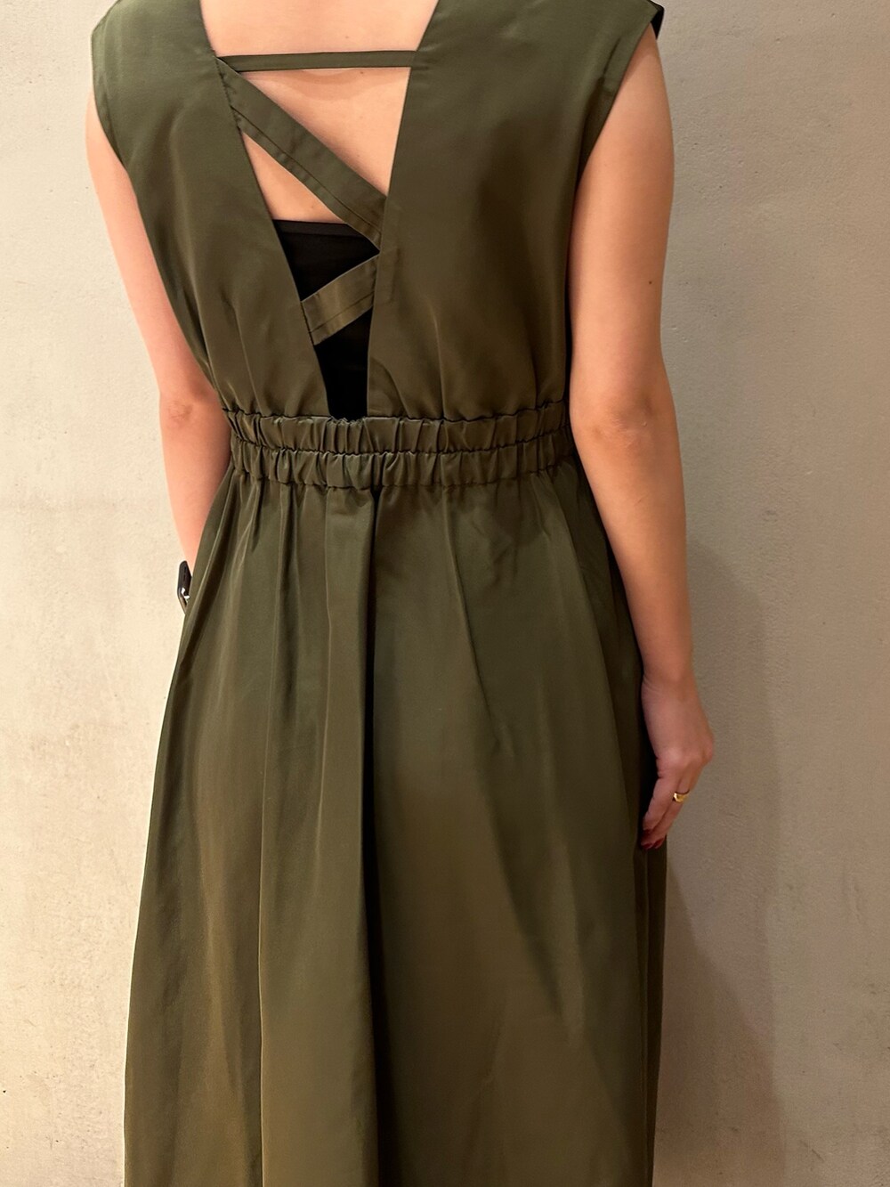 グリーン系のジャンパースカート、ブラック系のブーツを着用したレディースの夏コーディネートの7枚目の写真