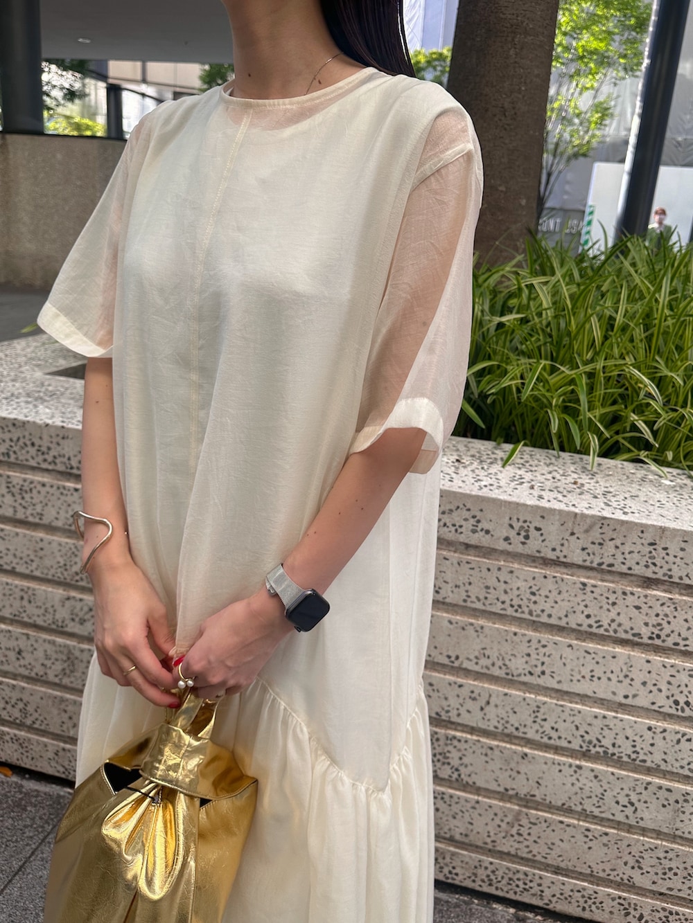 ブラック系のキャミソール、ゴールド系のハンドバッグ、ブラック系のサンダルを着用したレディースの夏コーディネートの4枚目の写真