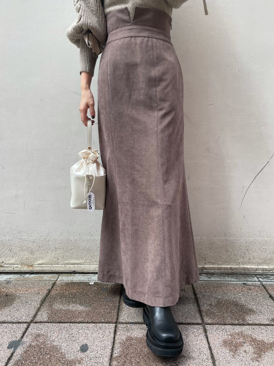 ブラック系のブーツ、ブラウン系のスカート、ベージュ系のニット/セーターを着用したレディースの秋コーディネートの6枚目の写真