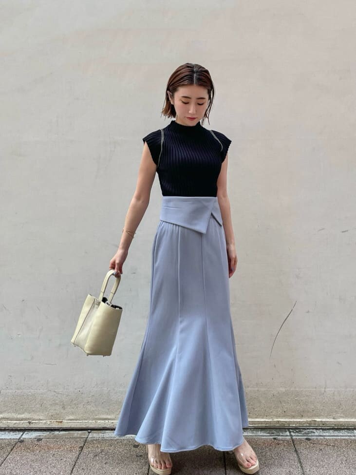 ブルー系のスカート、ブラック系のニット/セーターを着用したレディースの夏コーディネートの2枚目の写真