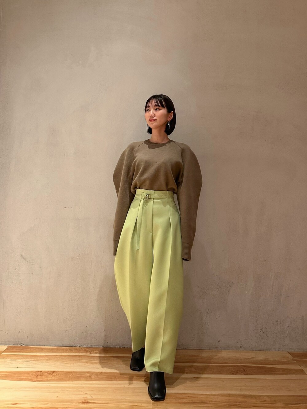 グリーン系のその他パンツ、ベージュ系のニット/セーター、ブラック系のブーティを着用したレディースの冬コーディネートの2枚目の写真