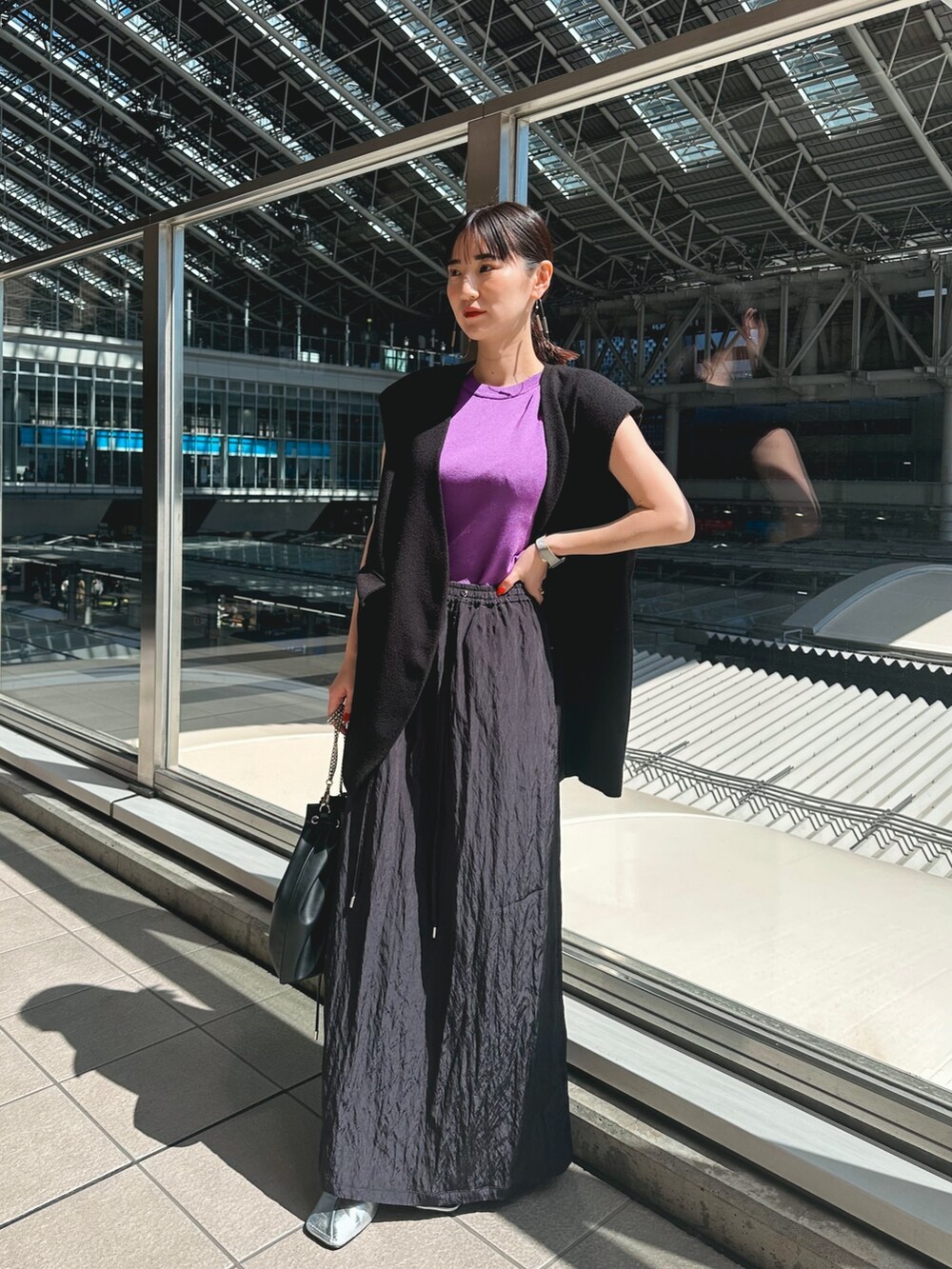 パープル系のニット/セーター、ブルー系のスカート、シルバー系のパンプスを着用したレディースの春コーディネートの5枚目の写真