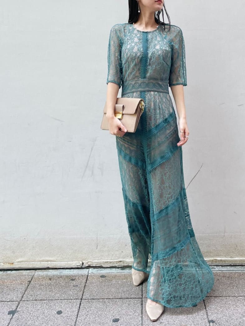 グリーン系のドレス、ベージュ系のパンプス、ブラウン系のクラッチバッグを着用したレディースの夏コーディネートの5枚目の写真