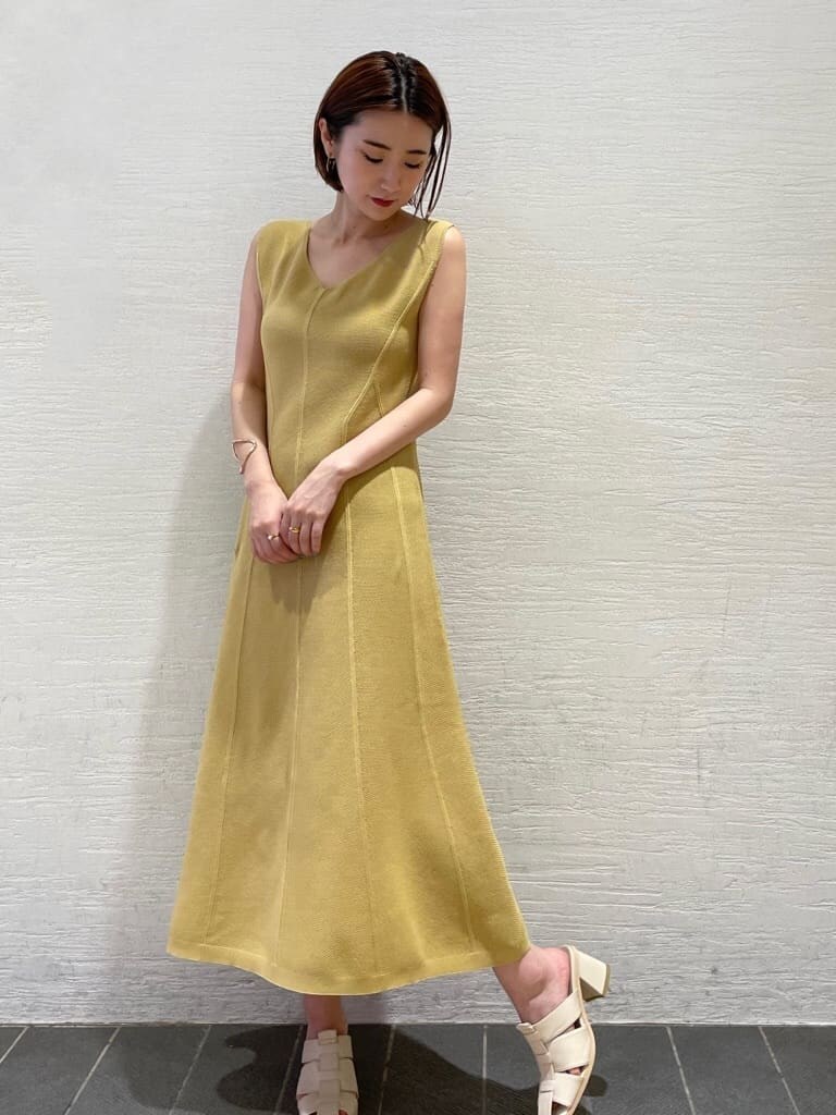 ホワイト系のサンダル、イエロー系のワンピース、ホワイト系のカーディガン/ボレロを着用したレディースの夏コーディネートの2枚目の写真