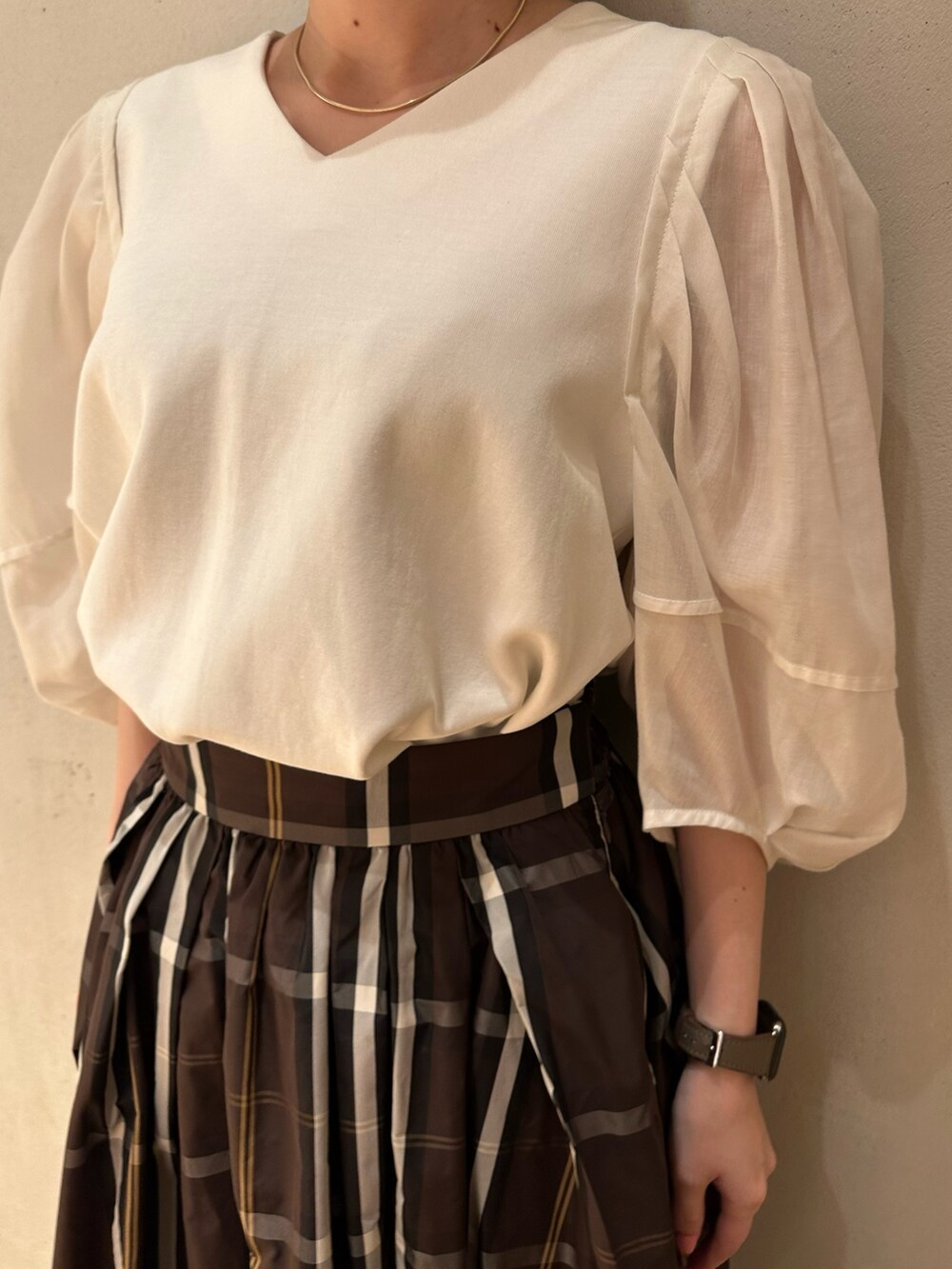 ホワイト系のTシャツ/カットソー、ブラウン系のスカート、ブラック系のパンプスを着用したレディースの春コーディネートの3枚目の写真