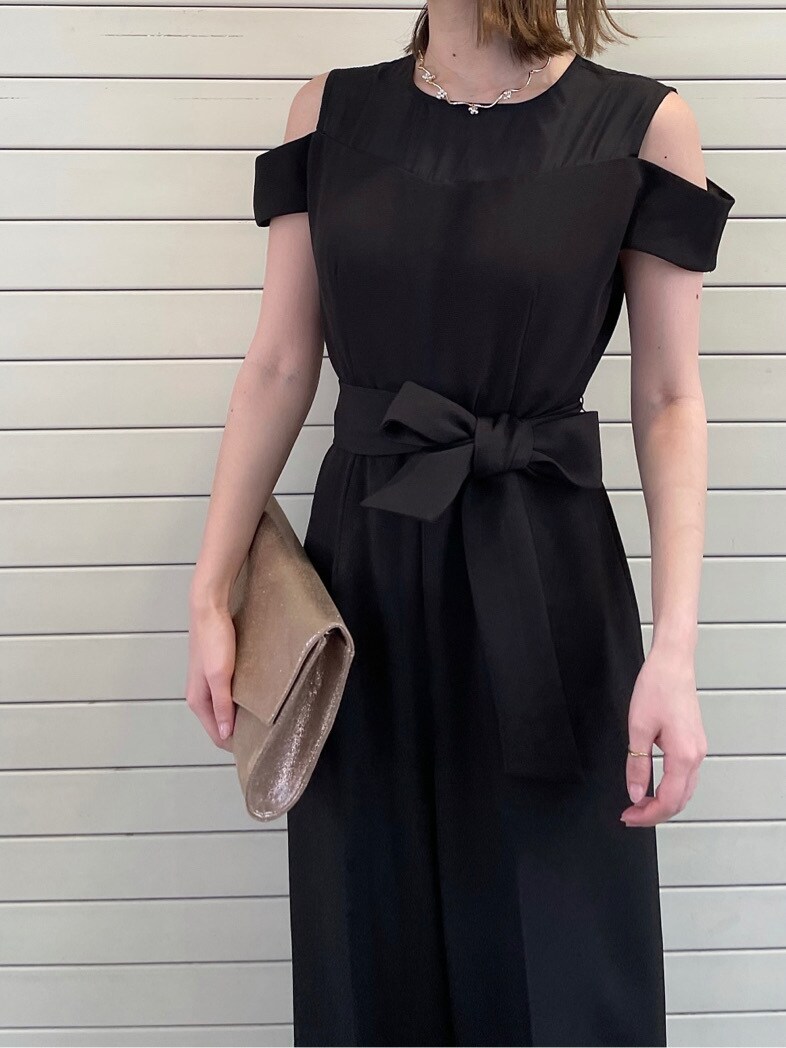 ブラック系のパンツドレス、ゴールド系のネックレスを着用したレディースの春コーディネートの4枚目の写真