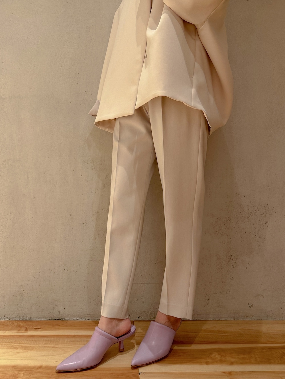 グレー系のその他パンツ、ベージュ系のハンドバッグ、ブラウン系のノーカラーコートを着用したレディースの冬コーディネートの4枚目の写真