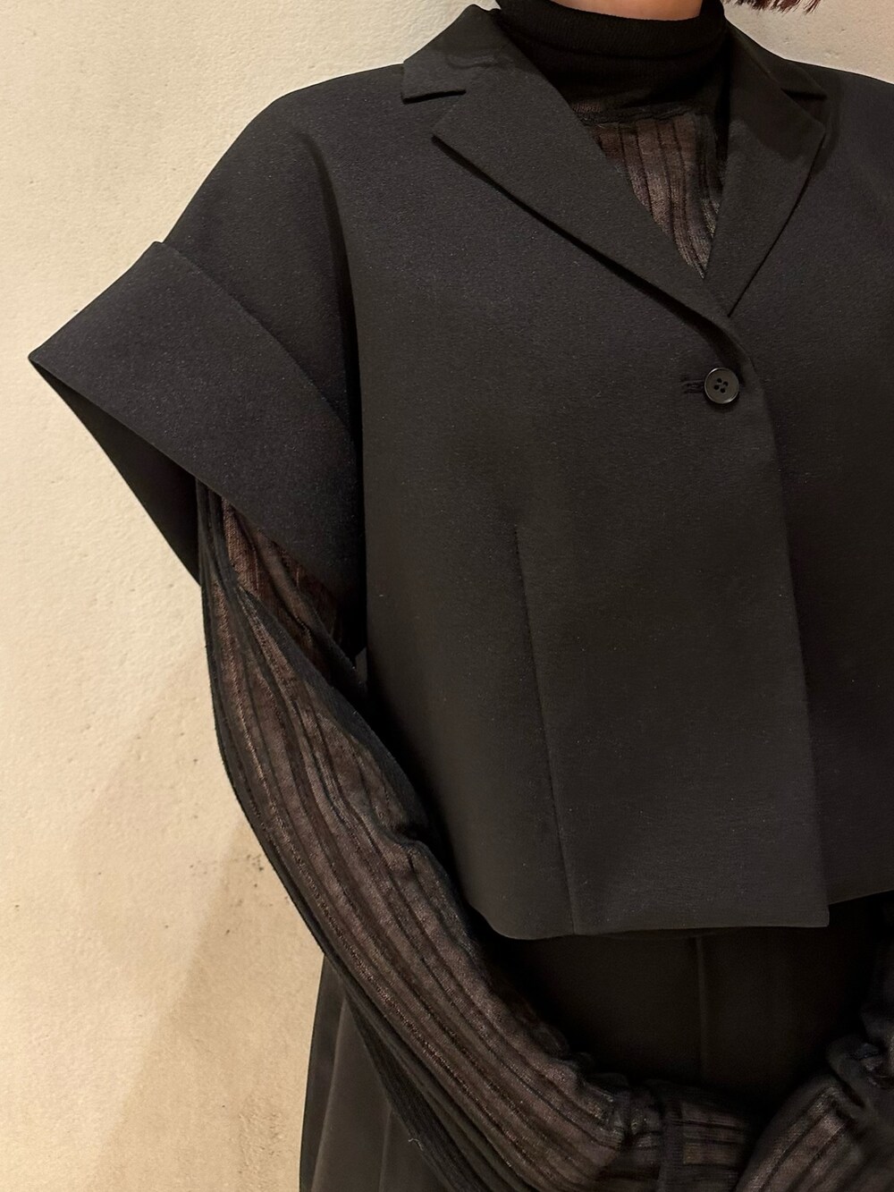 ブラック系のスラックス、ブラック系のニット/セーター、ブラック系のテーラードジャケットを着用したレディースの春コーディネートの5枚目の写真