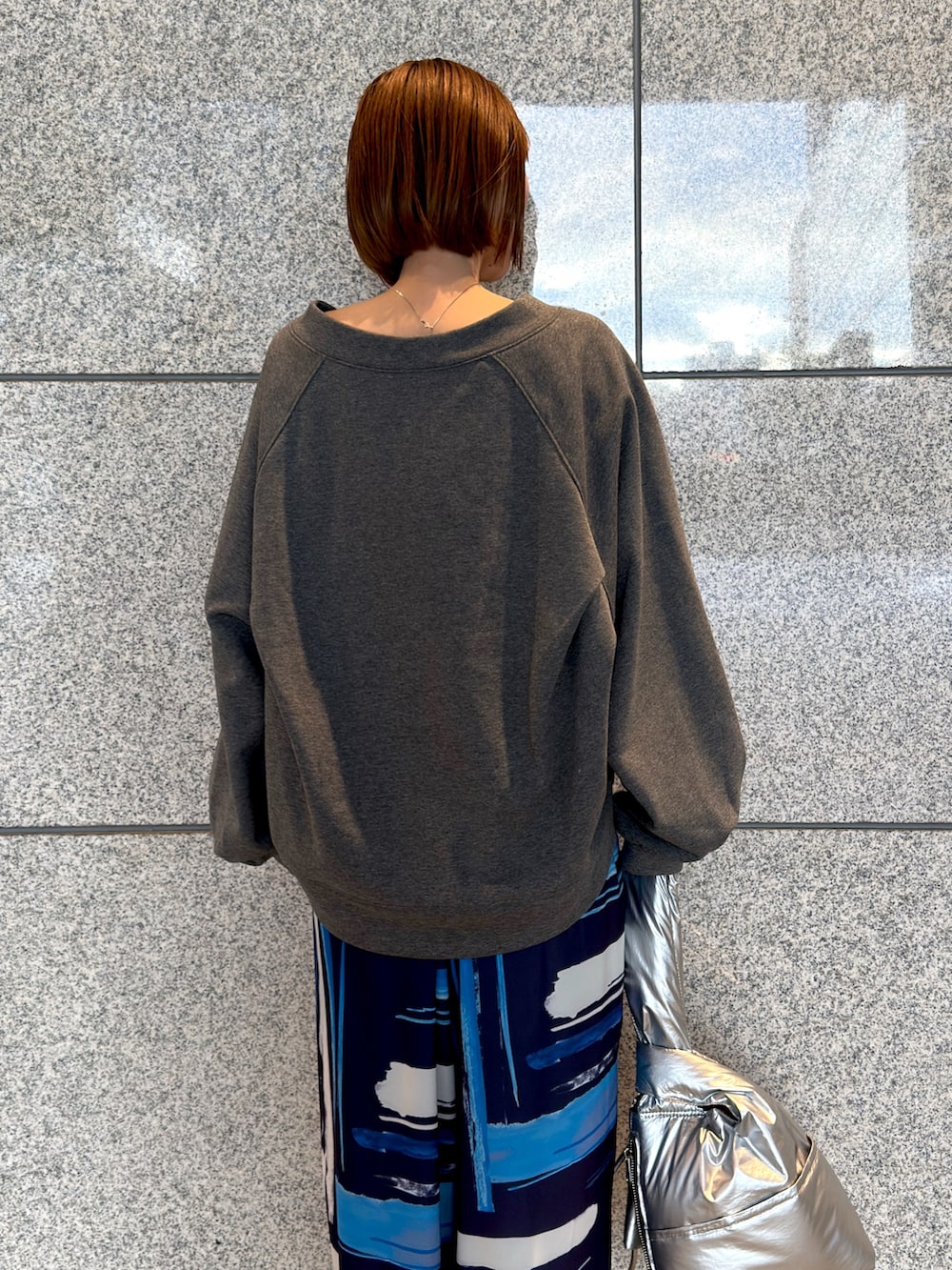 グレー系のTシャツ/カットソー、シルバー系のハンドバッグ、ブルー系のその他パンツを着用したレディースの冬コーディネートの3枚目の写真