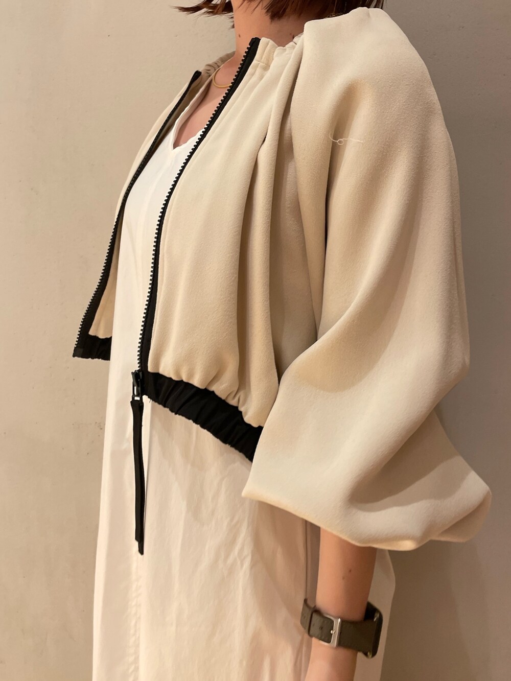 ホワイト系のワンピース、ブラック系のスニーカー、パープル系のスマホケース/カバーを着用したレディースの冬コーディネートの7枚目の写真